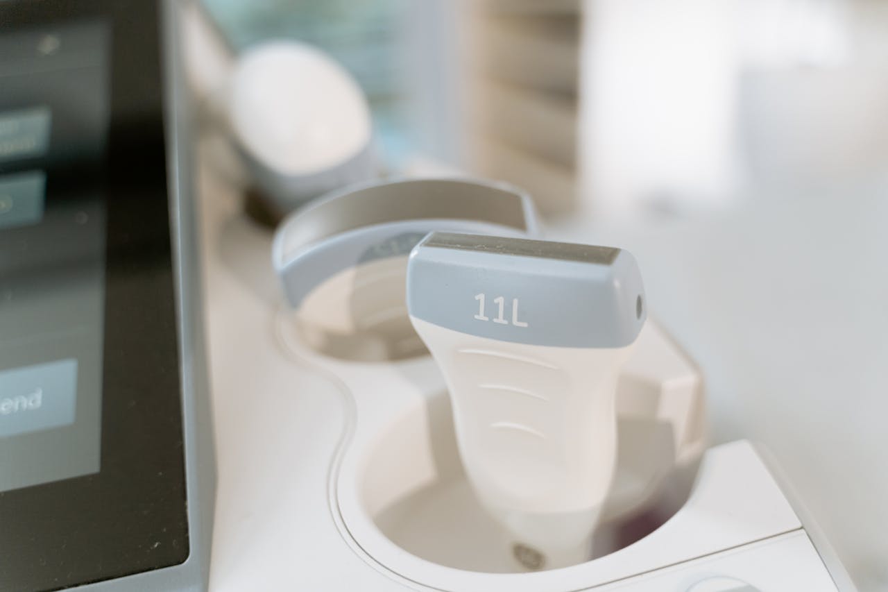 Detail shot of an ultrasound scanner probe in a medical facility setting.